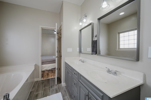 bathroom featuring vanity, wood-type flooring, and tiled bath