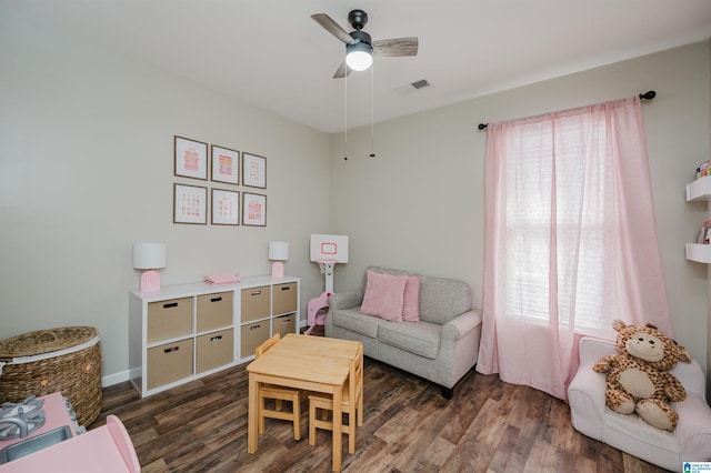 living area featuring ceiling fan and dark wood-type flooring