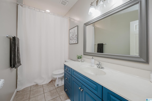 bathroom with toilet, vanity, and tile patterned floors