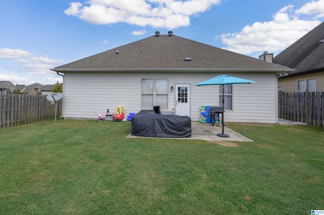 rear view of house with a lawn and a patio