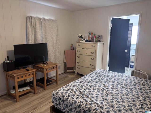 bedroom featuring hardwood / wood-style floors and wooden walls