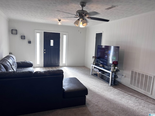 carpeted living room with a textured ceiling and ceiling fan