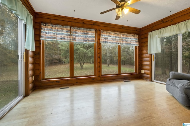 unfurnished sunroom with ceiling fan and a healthy amount of sunlight