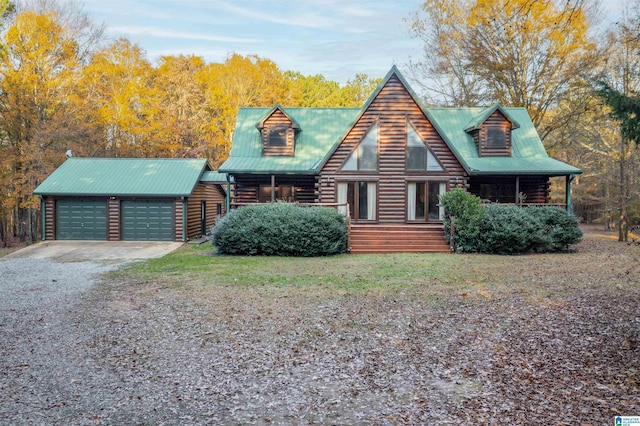 log-style house with a garage and an outdoor structure