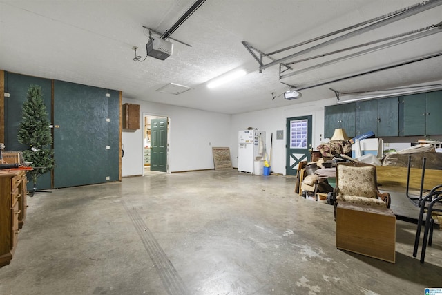 garage featuring white fridge and a garage door opener