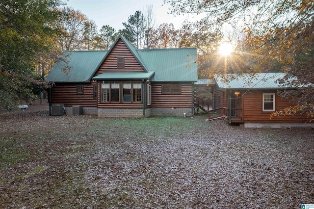 back house at dusk featuring cooling unit