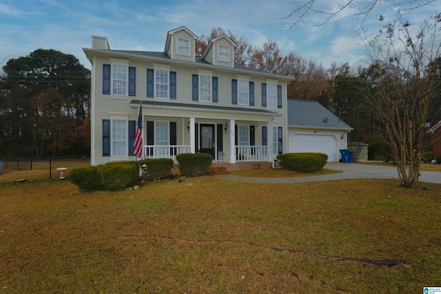 colonial home with a front lawn, covered porch, and a garage