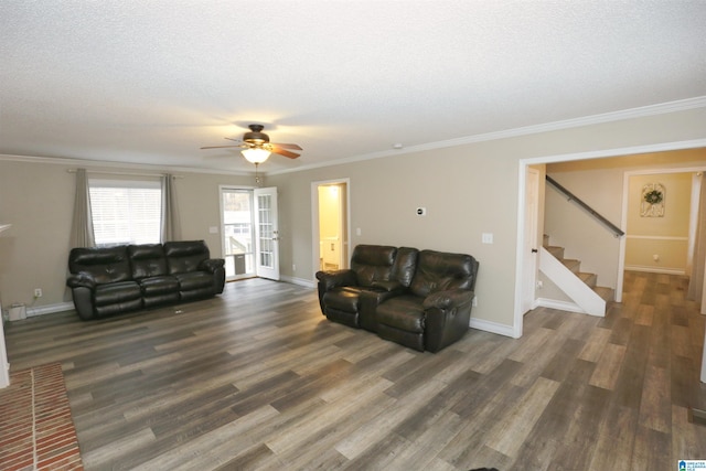 living room featuring ceiling fan, dark wood-type flooring, a textured ceiling, and ornamental molding