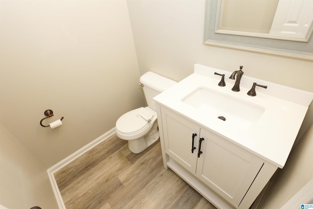 bathroom with hardwood / wood-style flooring, vanity, and toilet