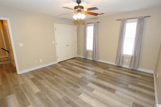 unfurnished bedroom featuring light wood-type flooring and ceiling fan