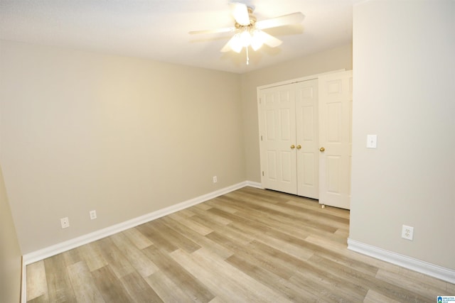 unfurnished bedroom featuring ceiling fan, light hardwood / wood-style floors, and a closet