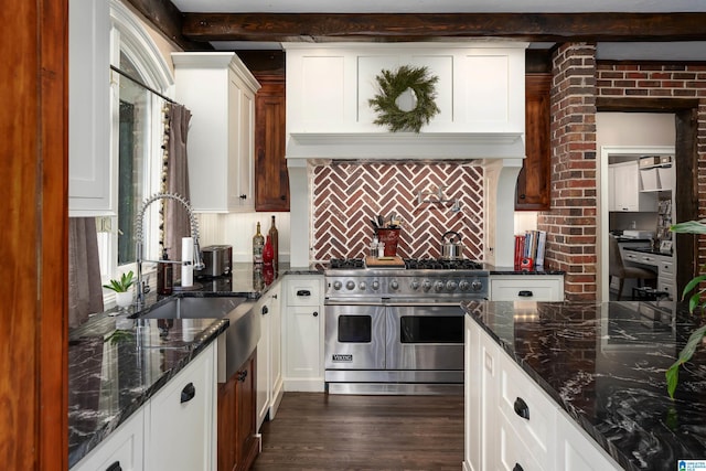 kitchen with decorative backsplash, dark stone counters, dark wood-type flooring, double oven range, and white cabinetry