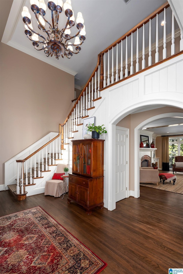 staircase featuring hardwood / wood-style flooring, an inviting chandelier, and ornamental molding