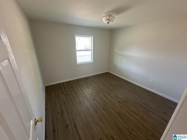 unfurnished room with dark hardwood / wood-style flooring