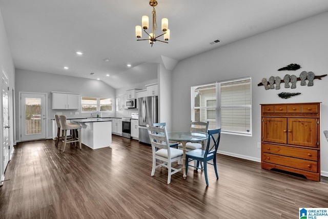 dining room with a chandelier, dark wood-type flooring, and lofted ceiling