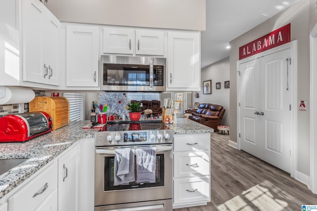 kitchen featuring white cabinets, stainless steel appliances, and light hardwood / wood-style flooring