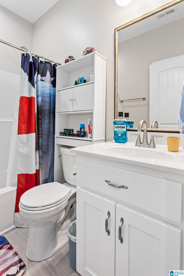 full bathroom with vanity, shower / bath combo, and toilet