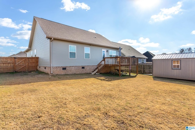 back of house with a storage unit, a deck, and a yard