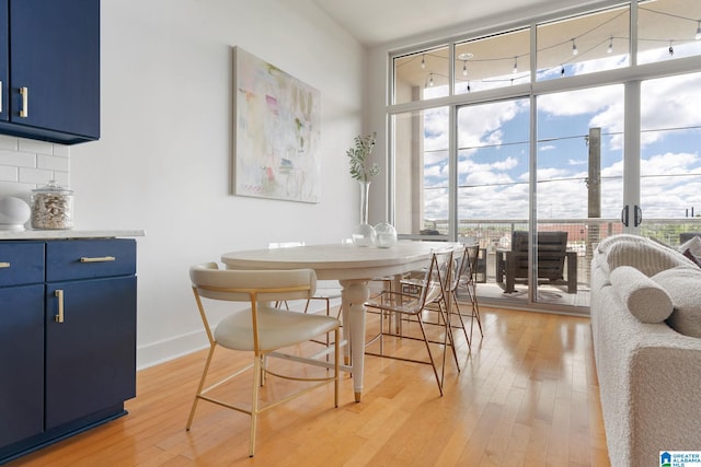 dining room featuring plenty of natural light, expansive windows, and light wood-type flooring