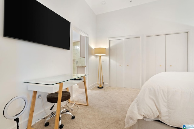 bedroom with carpet flooring, lofted ceiling, and two closets