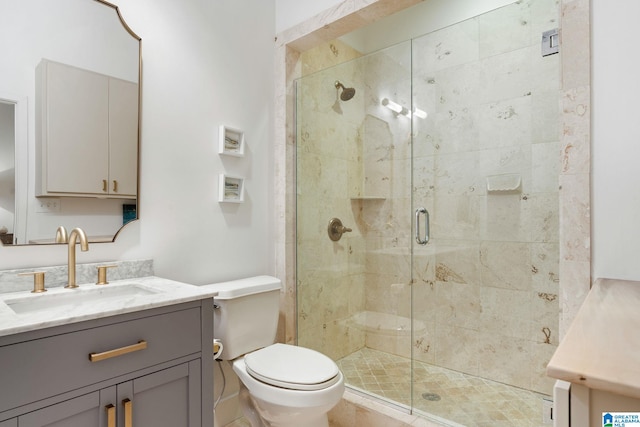 bathroom with a shower with door, vanity, and toilet