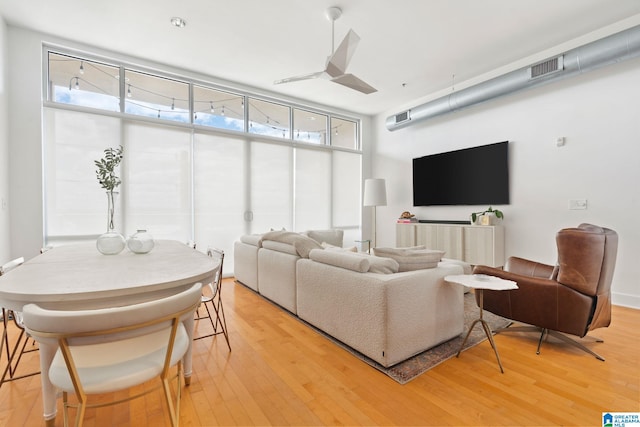 living room with ceiling fan and light hardwood / wood-style flooring