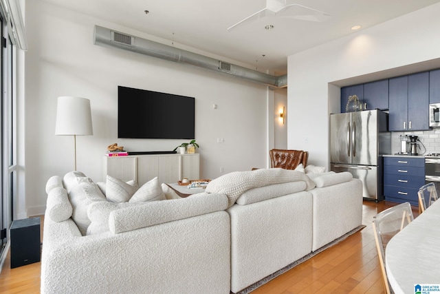 living room featuring light wood-type flooring and ceiling fan