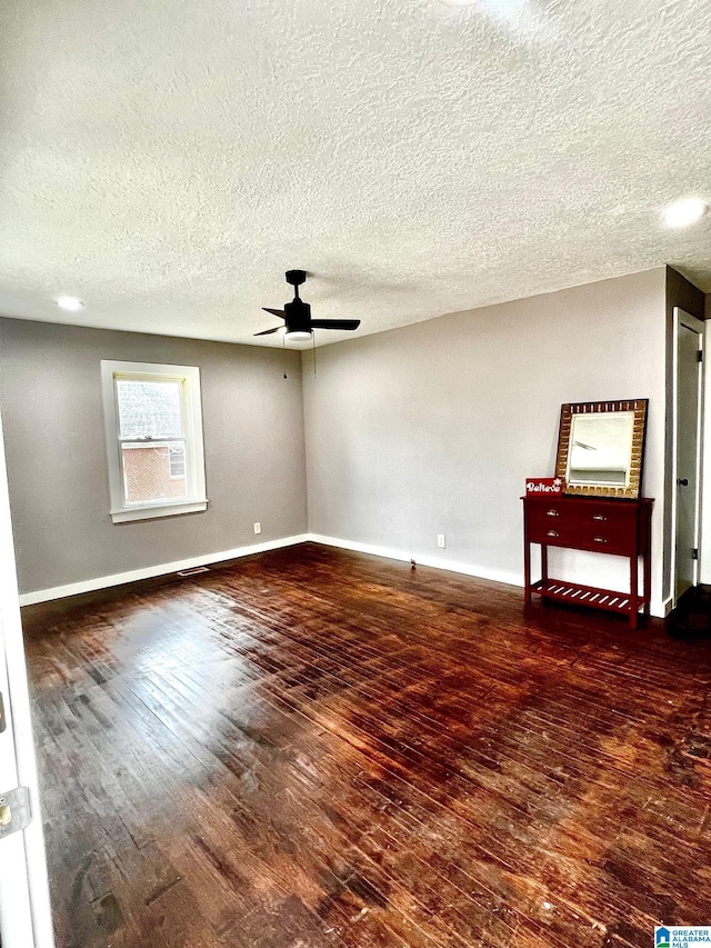 unfurnished room featuring a textured ceiling, dark hardwood / wood-style floors, and ceiling fan