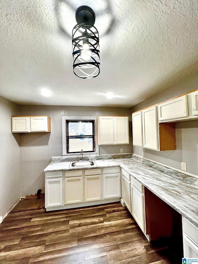 kitchen featuring sink, dark hardwood / wood-style floors, and a textured ceiling