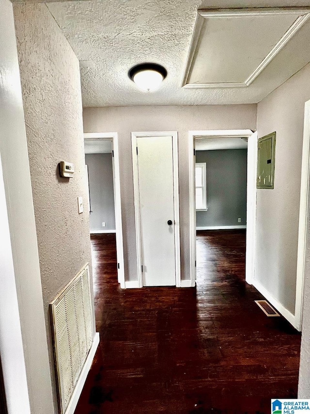 hall with dark hardwood / wood-style floors and a textured ceiling