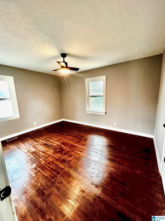 unfurnished room with hardwood / wood-style flooring, ceiling fan, and a textured ceiling