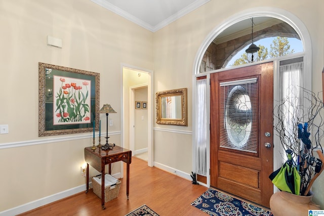 entrance foyer with crown molding, hardwood / wood-style floors, and lofted ceiling