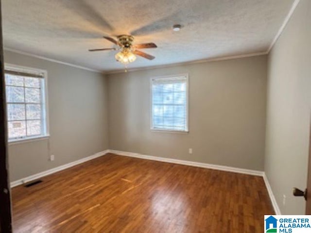 unfurnished room with a textured ceiling, crown molding, ceiling fan, and dark hardwood / wood-style floors