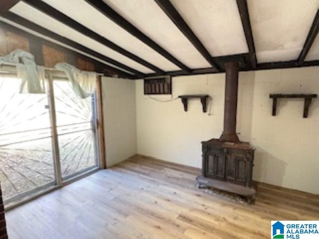 unfurnished living room featuring vaulted ceiling with beams and light hardwood / wood-style floors