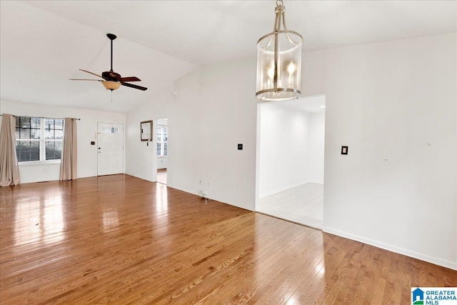 interior space with ceiling fan with notable chandelier, wood-type flooring, and lofted ceiling