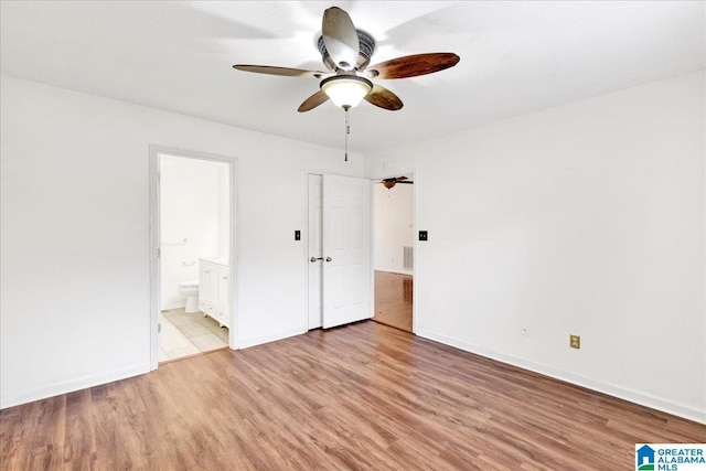 unfurnished bedroom featuring connected bathroom, ceiling fan, and light wood-type flooring