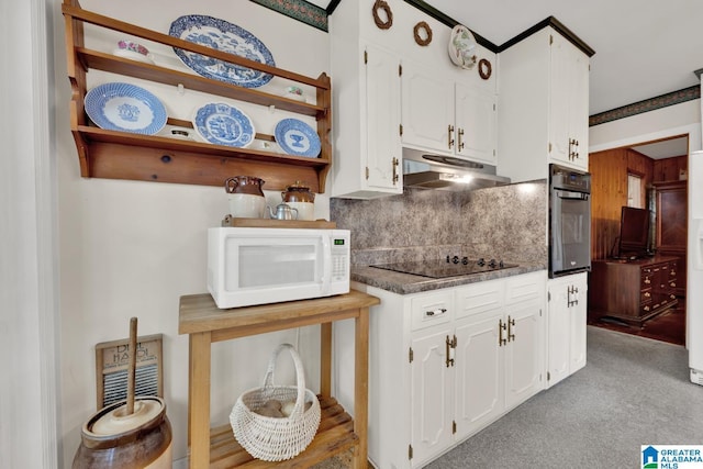 kitchen with white cabinets, oven, black electric cooktop, and backsplash