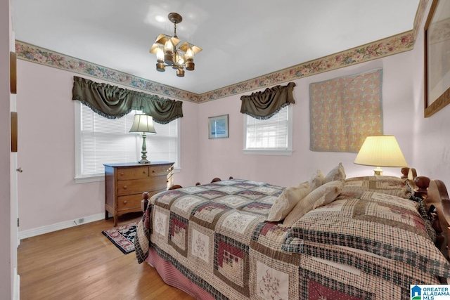 bedroom featuring a notable chandelier and light hardwood / wood-style flooring