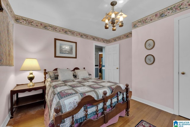 bedroom featuring hardwood / wood-style floors and a chandelier