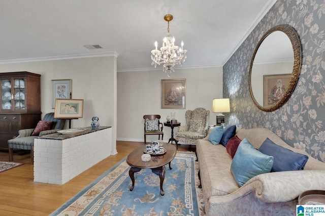 living room featuring a notable chandelier, light wood-type flooring, and crown molding