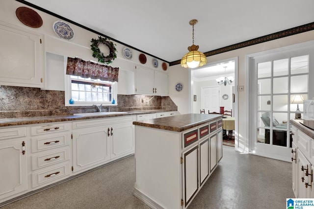 kitchen featuring white cabinets, a kitchen island, backsplash, and pendant lighting