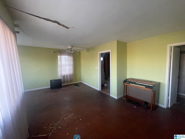 unfurnished room with ceiling fan and concrete flooring