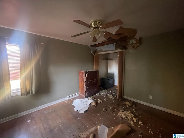 unfurnished bedroom featuring multiple windows, ceiling fan, and dark hardwood / wood-style floors