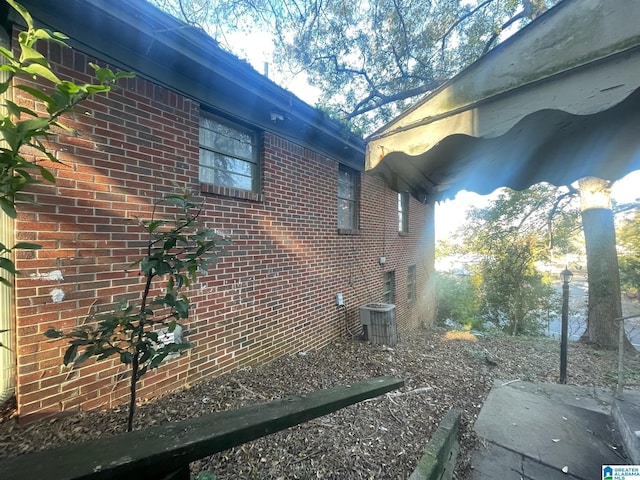 view of side of home with central AC unit