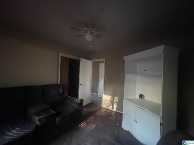 living room featuring ceiling fan and dark colored carpet