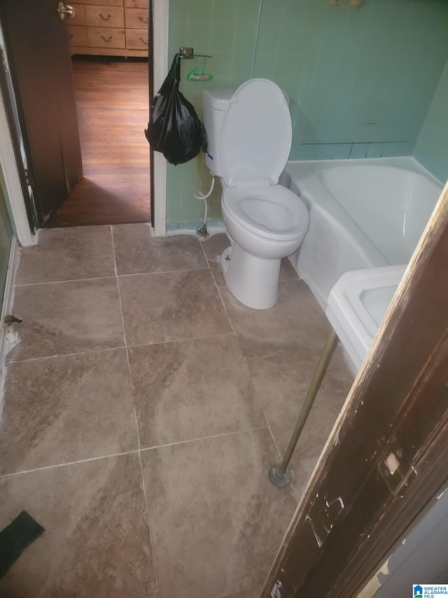 bathroom featuring a washtub, toilet, and wood-type flooring