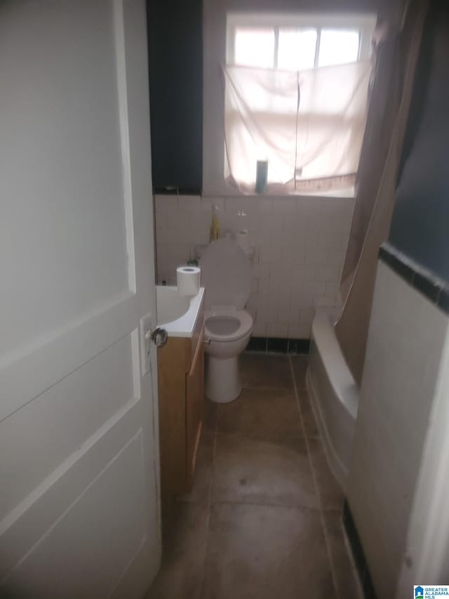 full bathroom with shower / tub combo with curtain, vanity, tile walls, and toilet