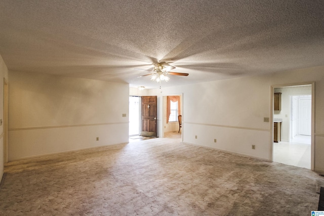 carpeted empty room featuring ceiling fan and a textured ceiling