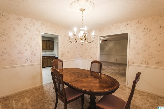 dining area featuring carpet floors, a textured ceiling, and a chandelier