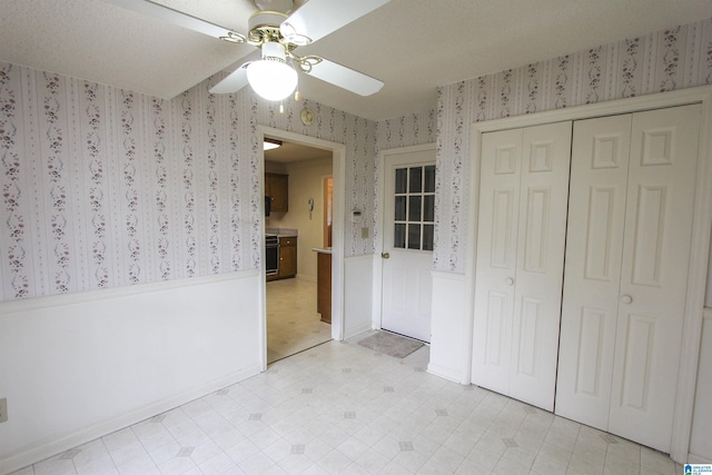 unfurnished bedroom featuring ceiling fan and a closet